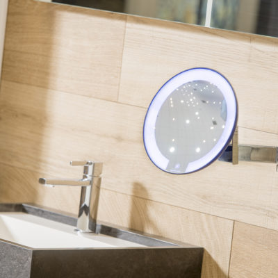 Der JVD beleuchtete Spiegel COSMOS in einem Hotelbadezimmer mit einem 5-Achsen-Gelenkarm und 5-facher Vergrößerung.