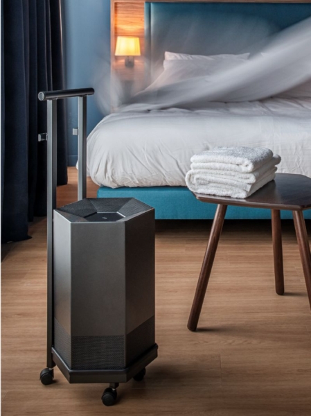 purificateur d'air shield by JVD dans une chambre d'hôtel sur un chariot de transport