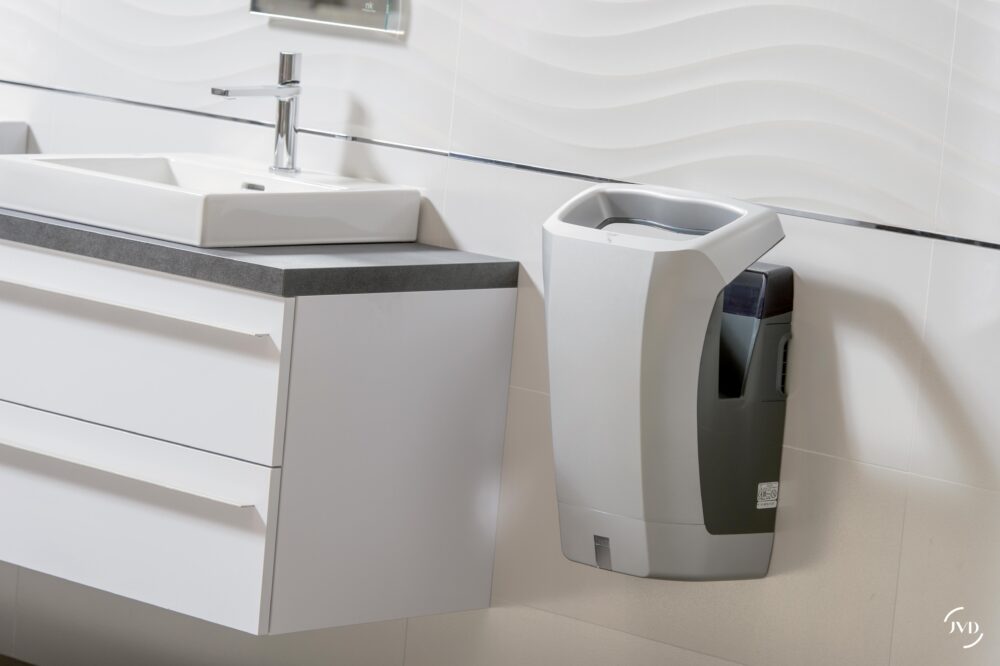 Secadores de manos eléctricos JVD en baño público.
