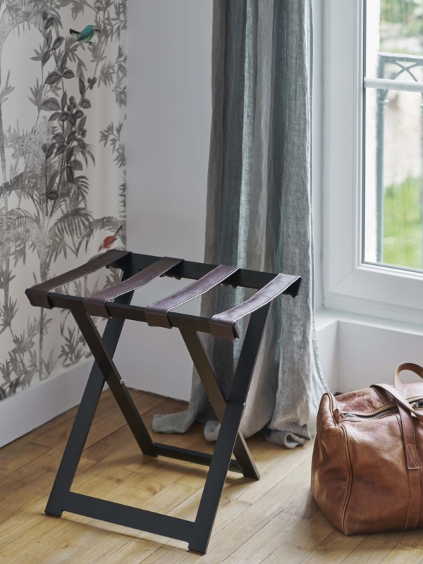 porte-valise en bois foncé dans une chambre d'hôtel