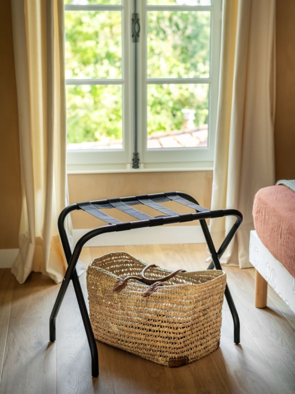 porte-bagages en métal noir dans une chambre d'hôtel